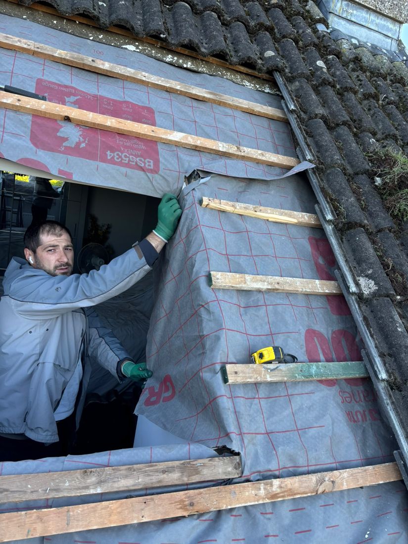 Roofer fitting a new roof window