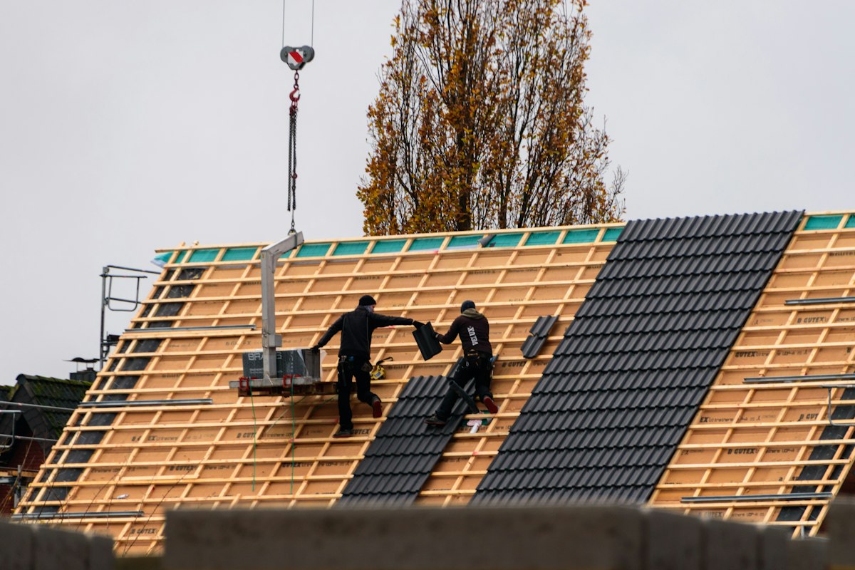 Roofers fitting new roof tiles